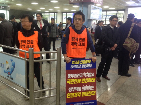 전국공무원노조 울산본부 권찬우 본부장(오른쪽)이 항의 피켓을 들고 11일 오후 4시 50분 울산공항에 도착하는 김 대표를 기다리고 있다. 