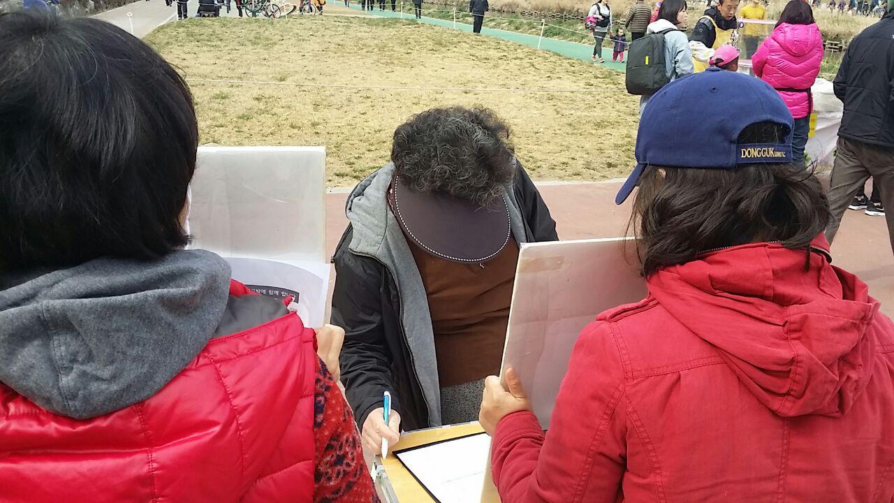 이명박 고발 설명을 듣던 70대 여성이 조용히 서명하는 모습