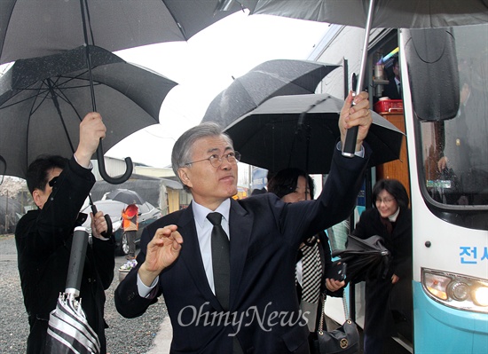 새정치민주연합 문재인 대표가 18일 아침 경남 김해 봉하마을을 방문해 고 노무현 전 대통령 묘역을 참배했다. 사진은 버스에서 내려 우산을 펼처 들어 보이는 모습.