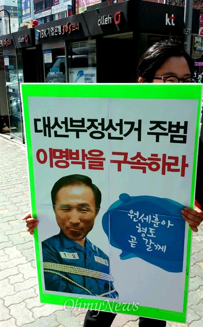 21일 오전 부산 서면에서 한 시민이 "대선 부정선거 주범 이명박을 구속하라"고 쓴 피켓을 들고 1인시위를 벌였다.