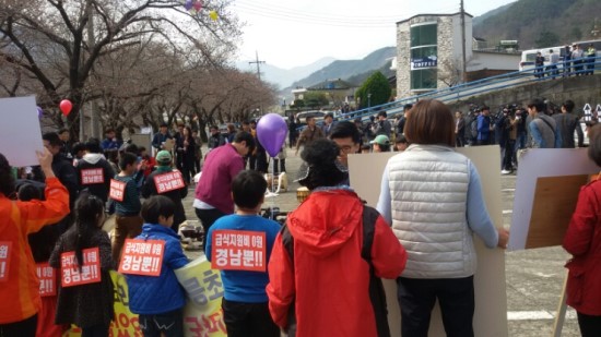 행사에 참가한 아이들과 학부모들이 사회자가 읽고 있는 결의문을 듣고 있다.