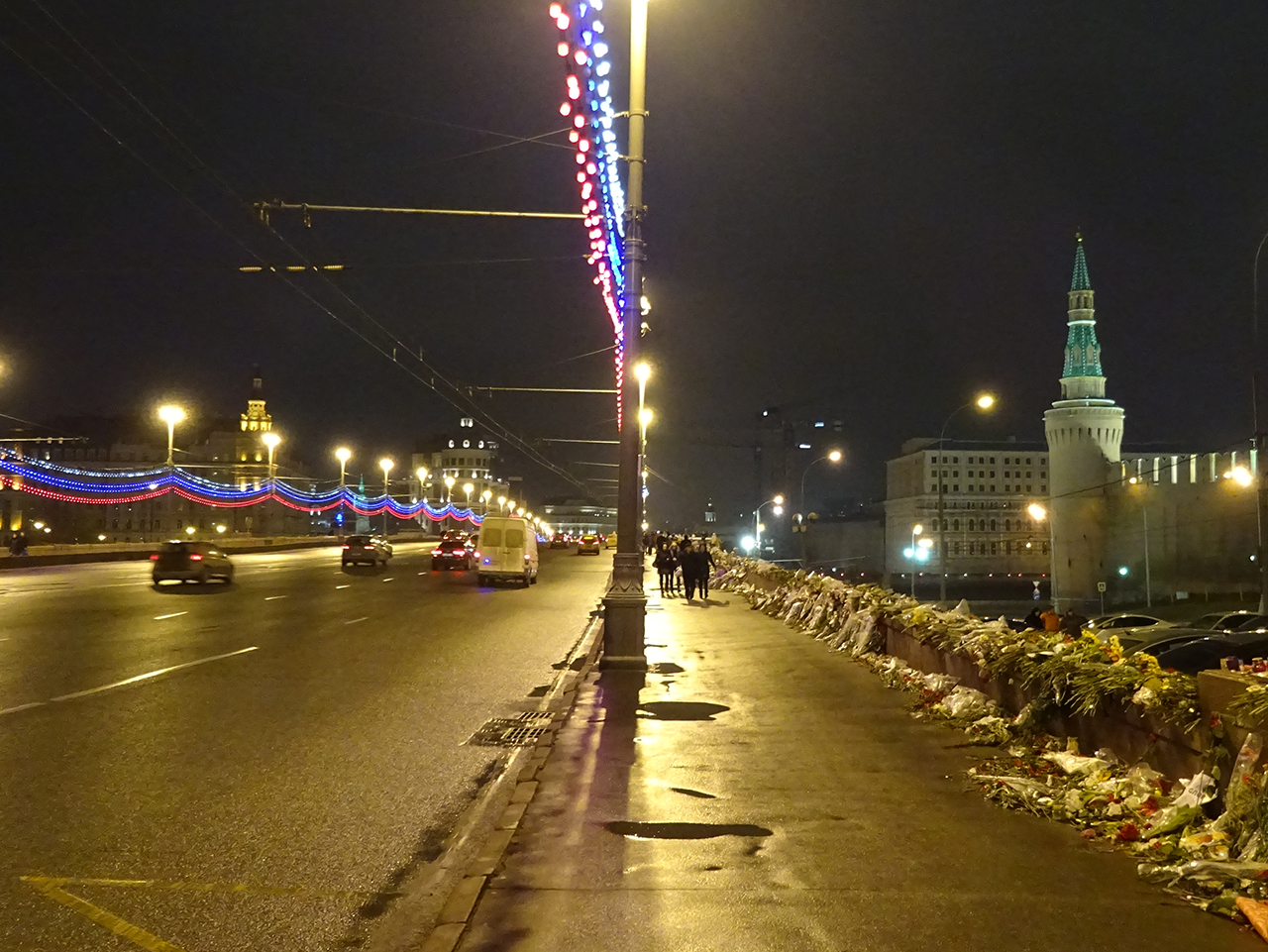 보리스 넴초프가 살해된 다리 위의 모습. 오른 쪽에 크렘린 궁이 보이고, 다리 오른쪽 난간을 따라 조화가 늘어서 있다. 