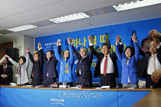 최고위원회의 도중 문 대표, 조 후보, 최고위원, 광주 지역 국회의원들이 "조영택 승리"를 다짐하며 손을 들고 있다.