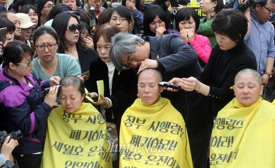 세월호 유가족들이 2일 오후 서울 종로구 광화문 세월호 농성장에서 정부가 발표한 배상·보상안에 반대하며 단체삭발을 진행하자, 이를 지켜보고 있던 시민들이 눈물을 흘리고 있다.
이날 이들은 정부의 배상·보상안 발표에 대해 "시행령안 폐기와 세월호 선체인양을 촉구하는 여론을 잠재우고 돈 몇 푼 더 받아내려고 농성하는 유가족으로 호도하려는 의도가 분명한 정부의 형태에 분노한다"며 "정부가 참사 1주기 이전에 해야 할 일은 배보상이 아니라 선체인향을 통한 실종자 완전 수습과 철저한 진상규명이다"고 말했다.