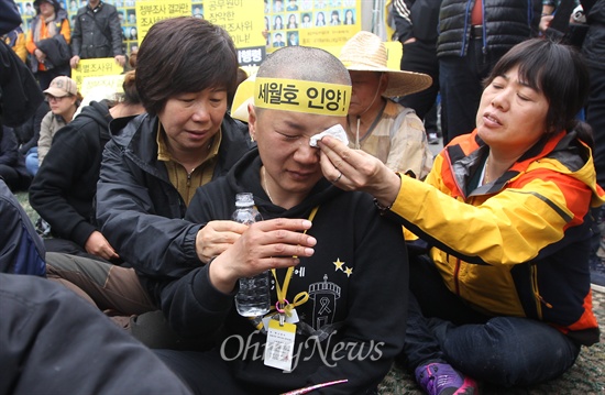 영석 엄마 "아들 먼저 가게 해서 미안해" 세월호 참사 희생자 오영석 학생의 어머니 권미화 씨가 2일 오후 서울 종로구 광화문 세월호 농성장에서 정부가 발표한 배상·보상안에 반대하며 삭발하자, 이를 지켜보고 있던 시민이 권 씨를 위로하고 있다.