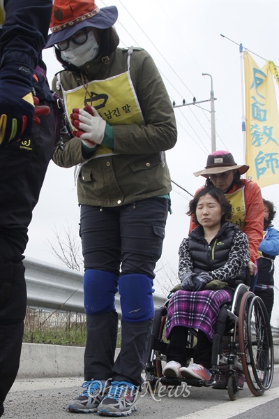 휠체어에 탄 한 시민이 삼보일배 행렬에 참여했다.