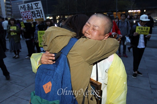 5일 오후 서울 종로구 광화문광장에서 열린 촛불문화제에 참석한 시민이 세월호 참사 희생자 오영석 학생의 어머니 권미화 씨를 안아주며 위로하고 있다.