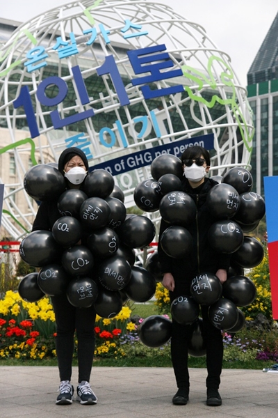 환경운동연합이 8일 서울광장에서 '온실가스 1인 1톤 줄이기'라고 적힌 이클레이 기념 조형물 앞에서 영흥 석탄화력발전 증설 계획의 폐기를 요구하는 퍼포먼스를 하고 있다.