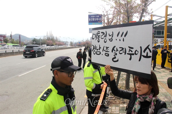 박근혜 대통령이 9일 오전 경남 창원을 방문한 가운데, 학부모들이 행사장 입구 도로가에 무상급식 재개를 바라는 내용의 피켓을 들고 서 있어 그 주변에 경찰이 지키고 서 있었다. 사진은 행사장 앞 도로에 홍준표 지사가 탄 것으로 추정되는 차량이 지나고 있는 모습.
