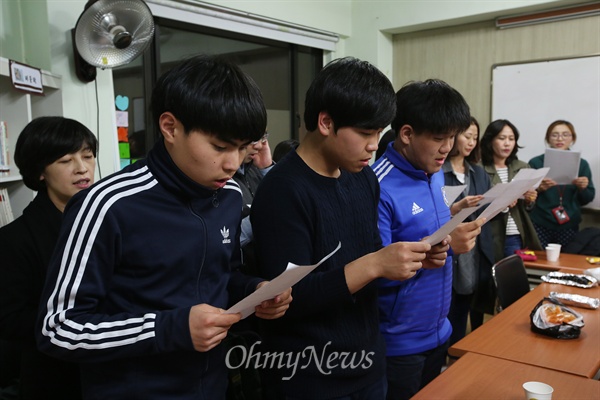 신방학중학교 3학년 손명훈, 김유민, 이현호군이 어른들과 함께 '약속해' 악보를 보며 노래연습을 하고 있다.