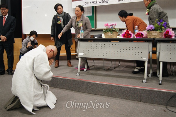 지난 9일 경북대학교에서 열린 한국군 베트남양민 학살 증언에서 명진 스님이 민간인 학살 현장에서 살아남은 응우옌 떤 런(64)씨와 응우옌 티 탄(57)씨 앞에서 무릎을 꿇고 용서를 빌고 있다.
