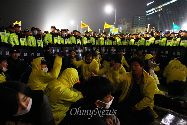  11일 오후 서울 광화문광장에서 세월호 사고 1주기를 맞아 열린 국민총력행동을 마친 시민과 세월호 유가족들이 청와대로 행진하던 중 경찰벽에 가로막혀 대치를 하다 바닥에 앚아 있다. 