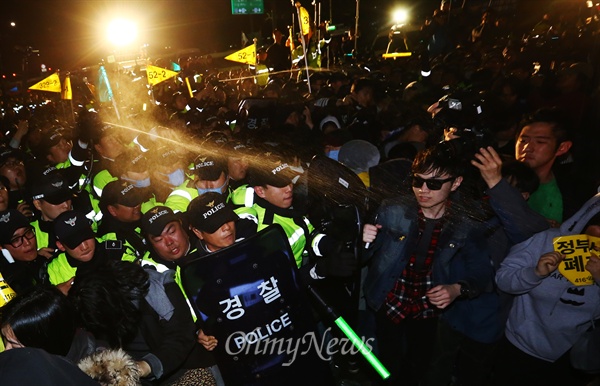 캡사이신 뿌리는 경찰 11일 오후 서울 광화문광장에서 세월호 사고 1주기를 맞아 열린 국민총력행동을 마친 시민과 세월호 유가족들이 청와대로 행진을 시작하자 경찰병력이 대치 도중 캡사이신을 뿌리고 있다. 