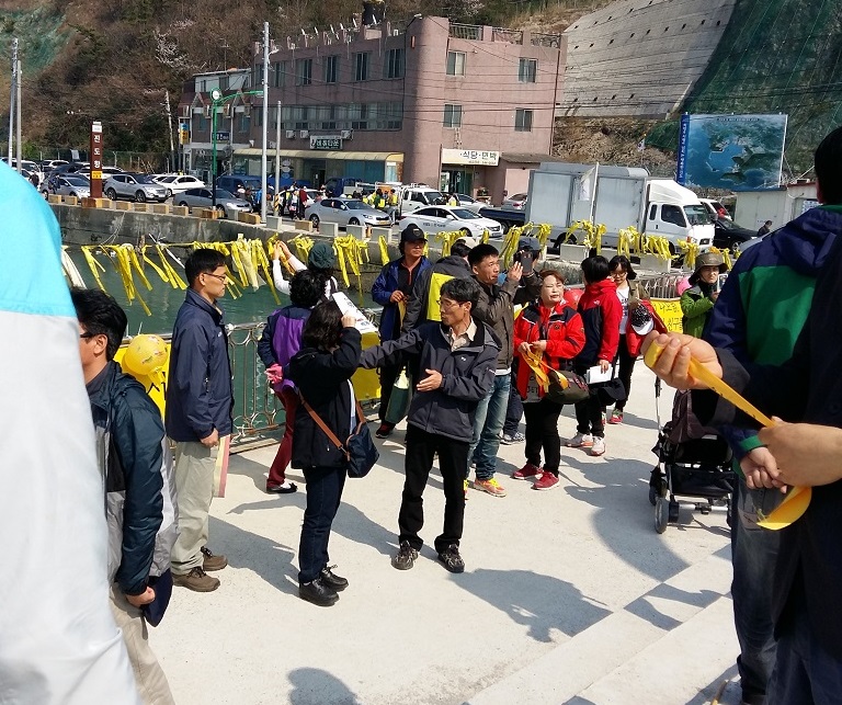 팽목항 방파제를 찾은 시민들이 노란 띠를 달기 위해 움직이고 있다.