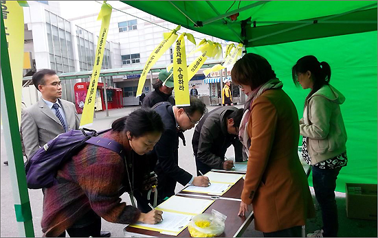 세월호 참사 1주년을 앞두고 '세월호참사대전대책회의' 회원이 대전역광장에서 천막농성을 하며 서명운동을 하고 있다.
