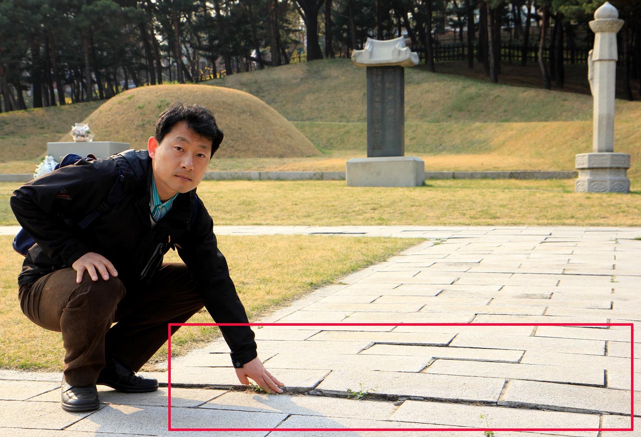 방학진 민족문제연구소 사무국장이 김구 주석 묘역의 움푹 패인 박석을 지적하고 있다.
