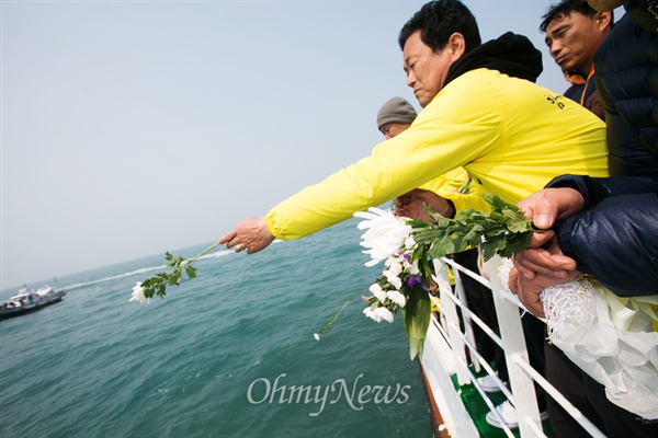  세월호 참사 1주기를 하루 앞둔 15일 오전 전남 진도 팽목항에서 사고해역을 방문한 유가족들 헌화를 하고 있다. 