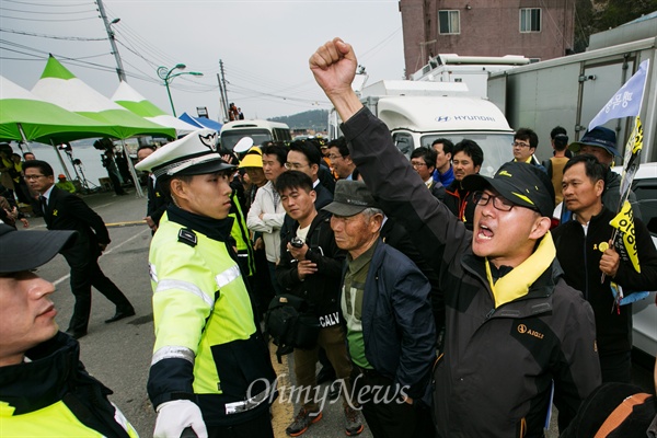 세월호참사 1주기인 16일 오전 전남 진도 팽목항에서 대국민담화를 마치고 떠나는 박근혜 대통령에게 한 시민이 "세월호를 인양하라"고 외치고 있다.