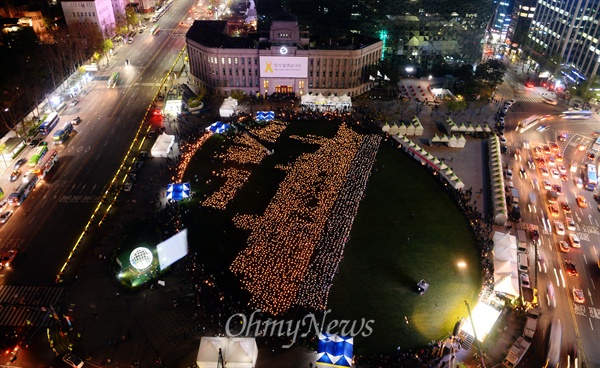 지난 17일 서울 시청 앞 서울광장에서 세월호 1주기를 맞아 4160명의 촛불로 세월호 형상을 만들어 기네스북 등재를 도전하고 있다. 