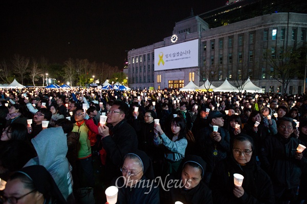 17일 서울 시청 앞 서울광장에서 세월호 1주기를 맞아 4160명의 시민들이 촛불을 들고 세월호 형상을 만들어 기네스북 등재를 도전하고 있다. 
