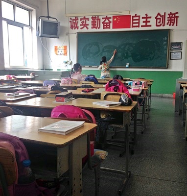 중국 초등학교 교실 전경. 수업시간이 끝나고 학생이 칠판을 지우고 있다.