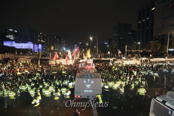  세월호참사 1주기를 맞아 18일 오후 서울광장에서 유가족과 시민들이 세월호특조위 시행령 폐지와 세월호 인양을 촉구하는 범국민대회를 열었다. 집회를 마친 시민들이 광화문광장에 집결하자 경찰이 물대포와 차벽으로 가로막고 있다.