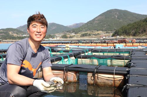 윤인범 씨가 양식장에서 꺼낸 전복을 들어보이며 전복양식에 얽힌 이야기를 들려주고 있다.