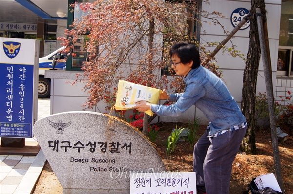 박근혜 대통령을 비방하는 전단지를 제작해 명예훼손으로 수사를 받고 있는 둥글이 박성수씨가 21일 오전 대구수성경찰서 앞에서 개사료를 뿌리고 있다.