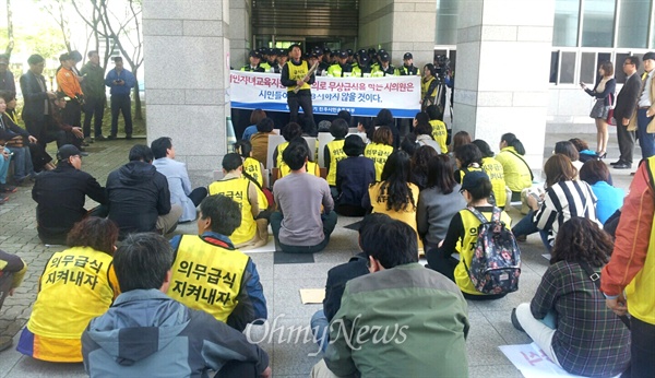  진주시의회가 21일 임시회 본회의를 열어 학교 무상급식 지원 예산을 전용해 사용하는 서민자녀교육지원조례를 다룰 예정인 가운데, 이 조례안에 반대하는 학부모들이 의회 앞에 모여 있자 경찰이 배치되어  막고 있다.