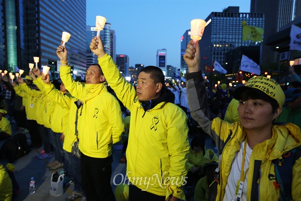 25일 오후 서울 광화문광장에서 열린 '세월호 특별법 대통령령 폐기 촉구 범국민추모문화제'에서 유가족들이 촛불을 밝히고 있다.