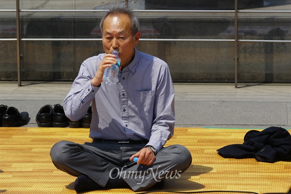 세월호특조위 이석태 위원장이 27일 오후 서울 광화문광장에서 '정부시행령 철회 대통령 결단 촉구' 연좌 농성을 하며 물을 마시고 있다.  