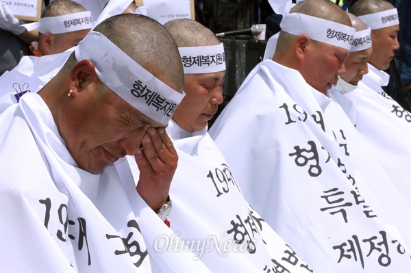  형제복지원 사건 피해 생존자들이 28일 오전 서울 여의도 국회 정문 앞에서 형제복지원 사건의 진상규명을 위한 특별법 제정을 촉구하며 삭발하던 도중 눈물을 흘리고 있다.