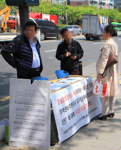 서울 지하철 강남구청역 입구에서 운동원들이 시민들의 반대서명을 받고 있다.