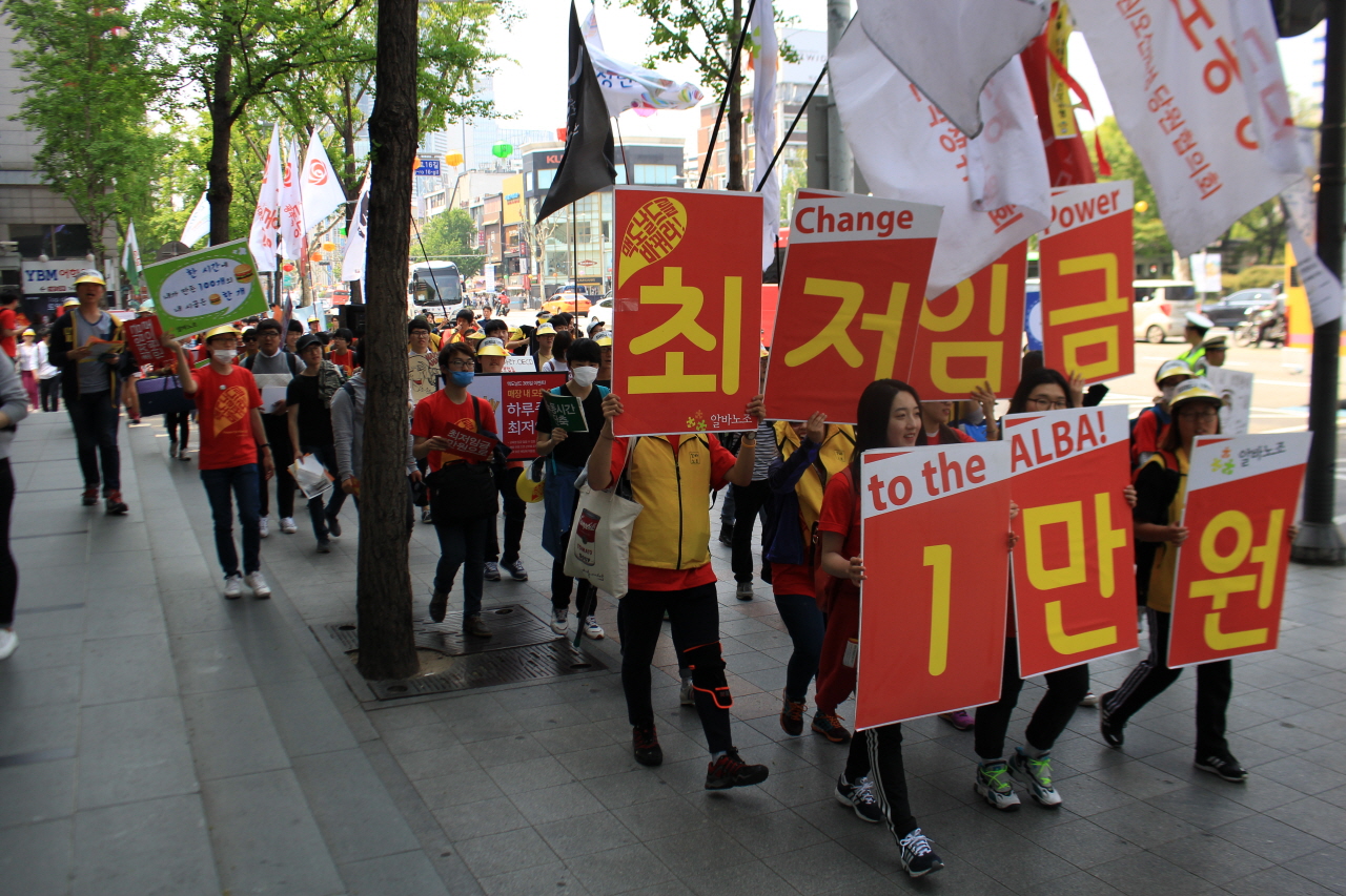 알바노조 조합원들이 '최저임금 1만원' 구호가 써진 피켓을 들고 행진하고 있다. 