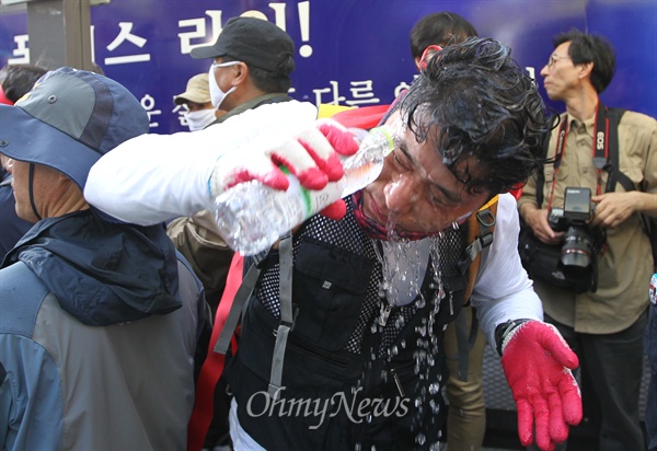 세계노동절 대회를 마친 민주노총 조합원들이 1일 오후 서울 종로구 인사동에서 청와대를 향해 행진을 벌이던 중 경찰이 뿌린 캡사이신을 물로 씻어내고 있다.