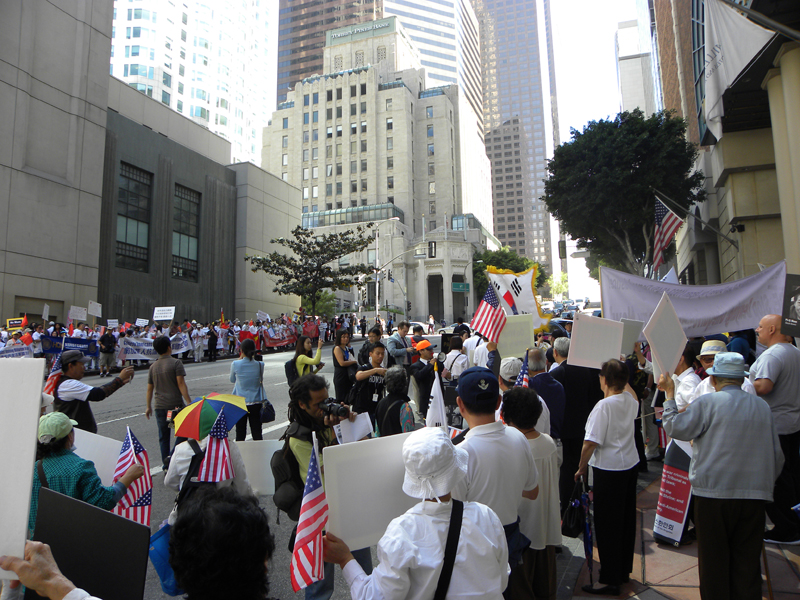 LA 다운타운에 위치한 빌트모어 호텔 정문 쪽에 한인 300여 명, 길 건너편에 중국인 300여 명이 아베 총리 반대 시위를 벌이고 있다.