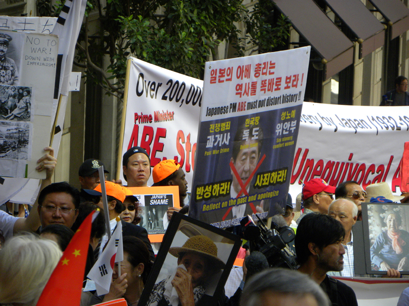 여러 한인들이 위안부의 사진을 들고 시위를 하고 있다.