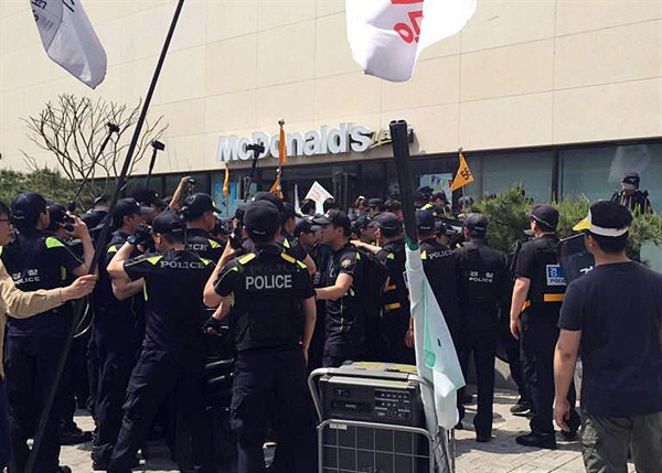 아르바이트 노동조합(알바노조) 회원들이 1일 오후 서울 종로 일대 행진 도중 패스트푸드점 앞에서 처우 개선 등을 촉구해 경찰이 이들을 둘러싸고 있다. 