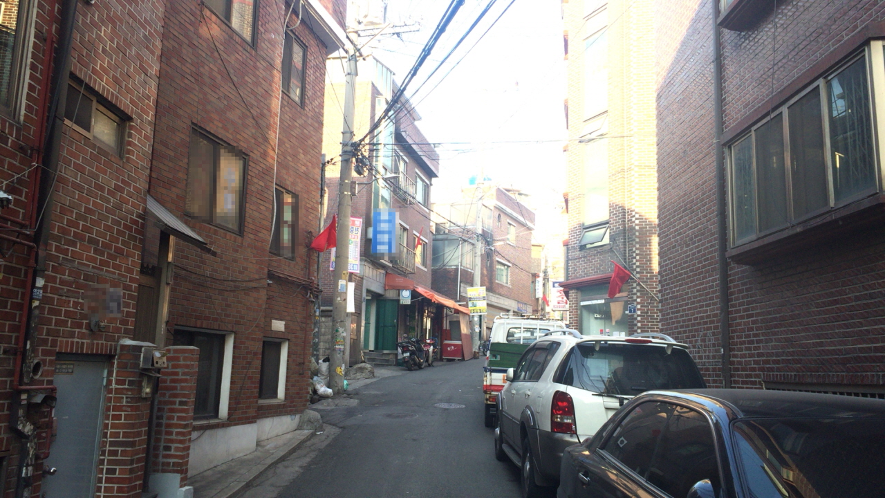 아현역 4번 출구로 나와 시장을 빠져나오면 북아현동의 주택가로 들어갈 수 있다. 북아현동의 주택가에서 재개발을 반대한다는 의미의 빨간 깃발을 달아 놓은 집을 쉽게 찾을 수 있다.