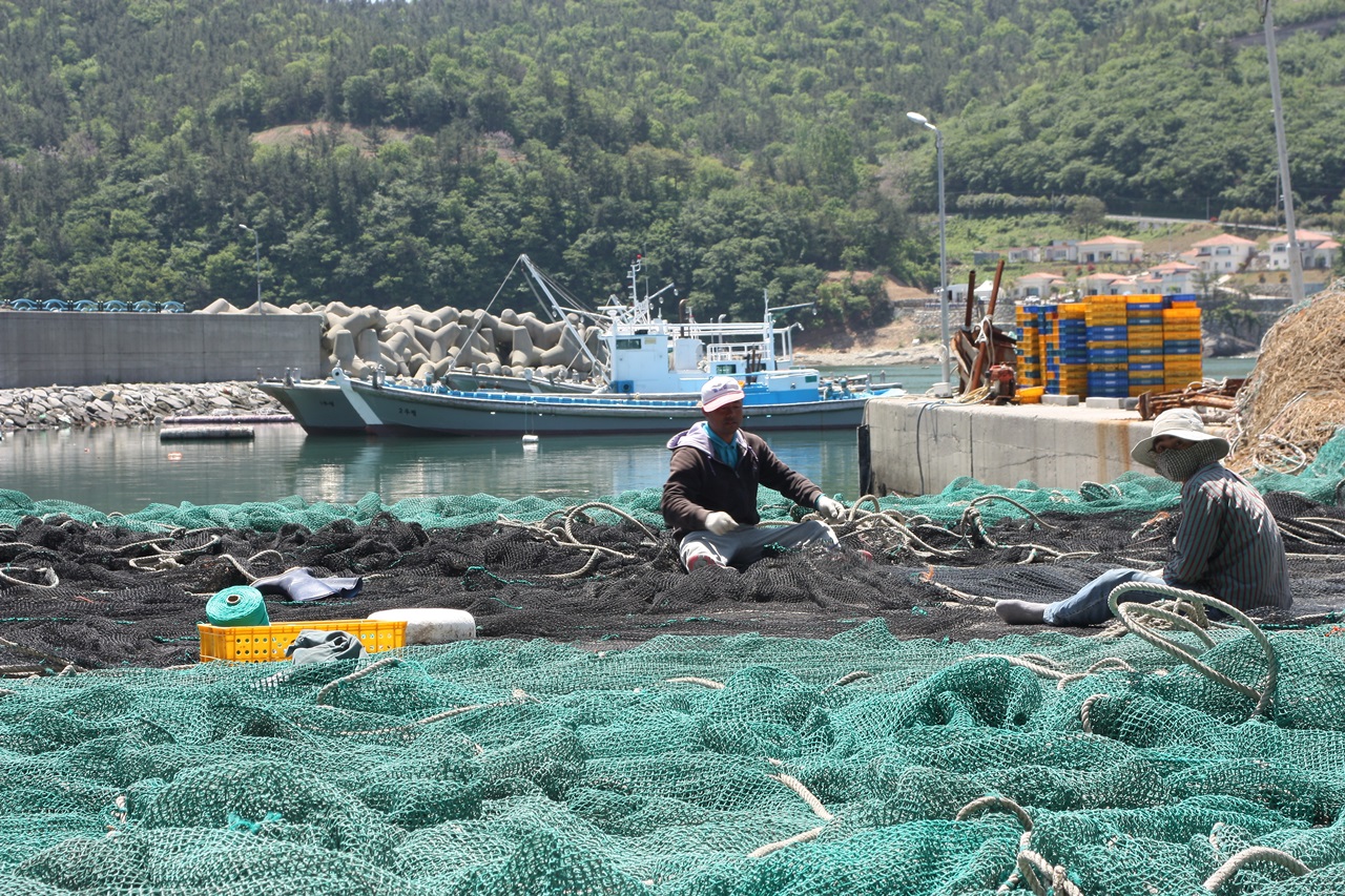 돌산갯가길 2코스 시작점인 돌산 계동선착장에서 어부들이 그물을 손질하고 있다.