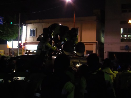 '소음관리'라고 적힌 옷을 입고 있는 경찰이 일반노조 방송차량을 에워싸고 스피커을 떼어갔다.