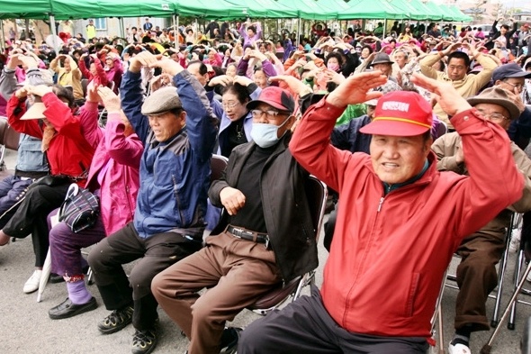2012년 4월 열린 광주 광산구 더불어락 노인복지관 북카페 개관잔치에 참석한 노인들이 머리 위로 하트를 그려 보이고 있다.