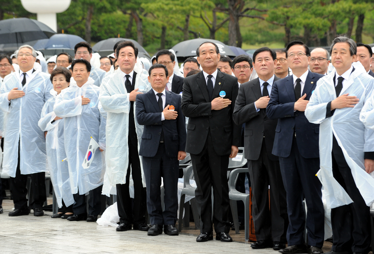 윤장현(사진 왼쪽에서 5번째) 광주광역시장이 20일 발표한 <열린 5·18로 당당하게 나아갑시다>라는 제목의 5·18 메시지에 대한 원성이 높아지고 있다. 윤 시장은 17일 전야제에서 있었던 김무성 새누리당 대표에 대한 물세례를 "옥의 티"라며 "이번 일은 5·18이 배타성과 지역성에서 벗어나야 함을 일깨워주고 있다"라고 밝혔다. 이에 대해 광주지역 시민사회단체는 21일 성명을 내고  "광주시민이 아닌 김무성 대표에게 보내는 사과문으로 착각될 만큼 시민의 뜻과 배치되어 부끄러울 지경"이라며 "5·18을 배타성과 지역성에 가둔 것은 되레 새누리당과 박근혜 정권이다"라고 반발했다. 이들 단체는 "시민을 모독한 윤 시장은 시민에게 사과하라"고 요구했다. 사진은 지난 18일 광주 운정동 5·18국립묘지에서 열린 35주년 기념식 모습.