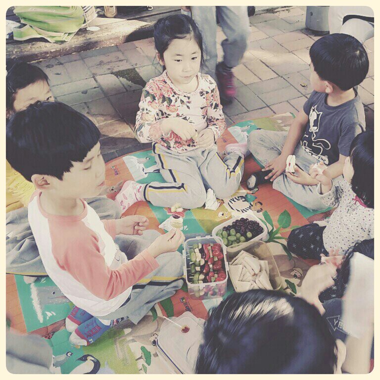 아이들이 엄마들이 싸온 간식을 함께 나눠먹고 있다.