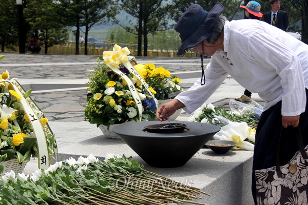23일 오후 경남 김해 진영읍 봉하마을 고 노무현 전 대통령 묘역에서 열린 서거 6주기 추도식에 참석한 한 시민이 분향하고 있다.