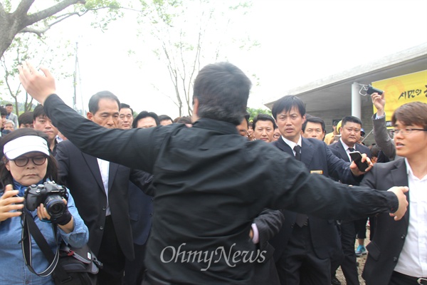 23일 오후 봉하마을에서 열린 고 노무현 전 대통령 서거 6주기 추도식에 참석한 새누리당 김무성 대표가 차량에서 내려 행사장으로 걸어가자 한 젊은 남성이 두 팔을 벌려 들어가지 못하도록 항의하고 있다.