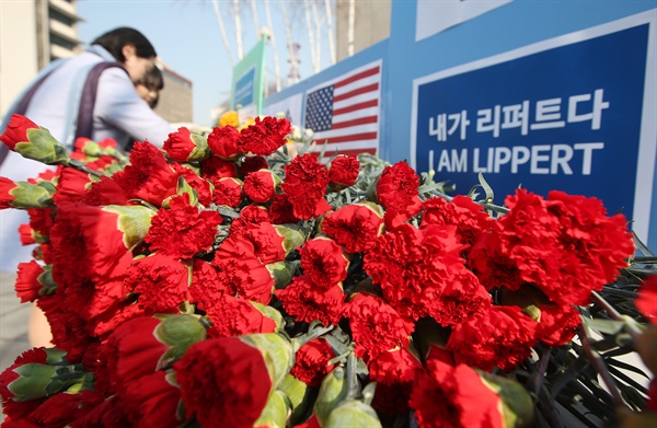 보수단체 자유한국청년회 회원들이 3월 6일 서울 종로구 세종대로 주한 미국대사관 인근에서 마크 리퍼트 주한 미국대사의 쾌유를 기원하는 의미로 카네이션을 펼쳐놓고 있다. 이 단체에 따르면 카네이션은 리퍼트 대사의 고향인 미국 오하이오주를 상징하는 꽃이다. 
