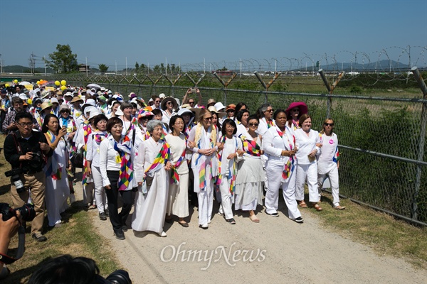 24일 오후 경기도 파주 통일대교 남단 일대에서 위민크로스DMZ 여성운동가들과 시민환영단이 함께 민통선 철책옆 길을 걸어 임진각을 향해 행진을 하고 있다. 