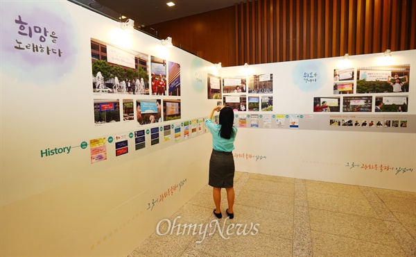 27일 오후 서울 종로구 교보생명빌딩에서 열린 '광화문글판 25년 맞이 공감콘서트' 행사장에 설치된 '글판 연대기'를 한 시민이 관람하고 있다. 