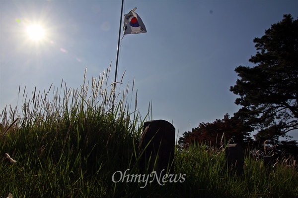 2015년 5월 27일, 5.18 구묘역에 게양된 조기 사이로 강한 햇살이 쏟아지고 있다.
